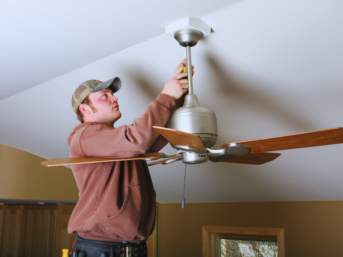 Electrician installing ceiling fan 
