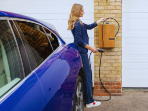 Woman charger car in her driveway with level 2 EV charger