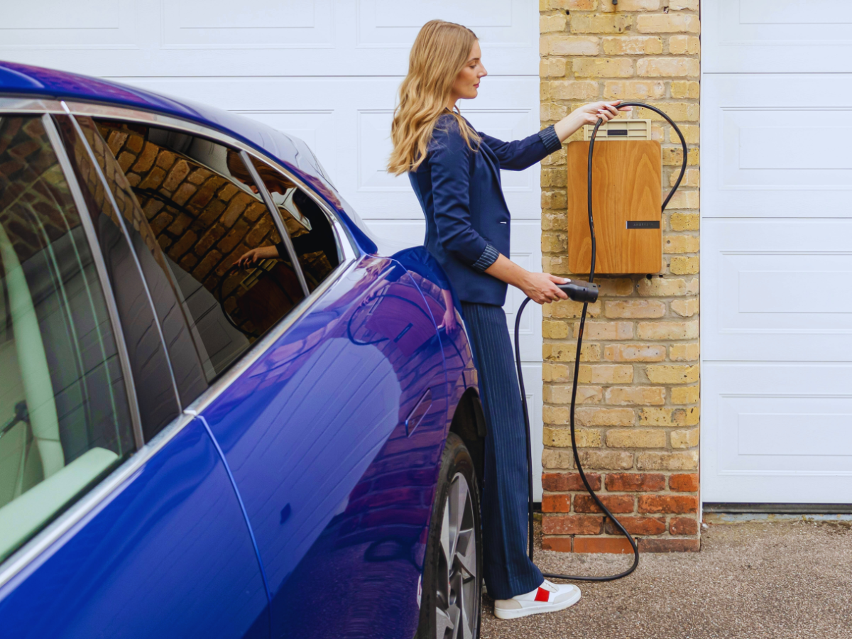 Woman charger car in her driveway with level 2 EV charger